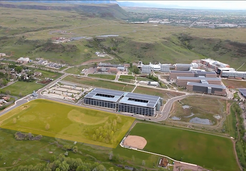 A photograph from the air of the NREL campus made of about seven buildings with an empty lot east of the parking garage highlighted